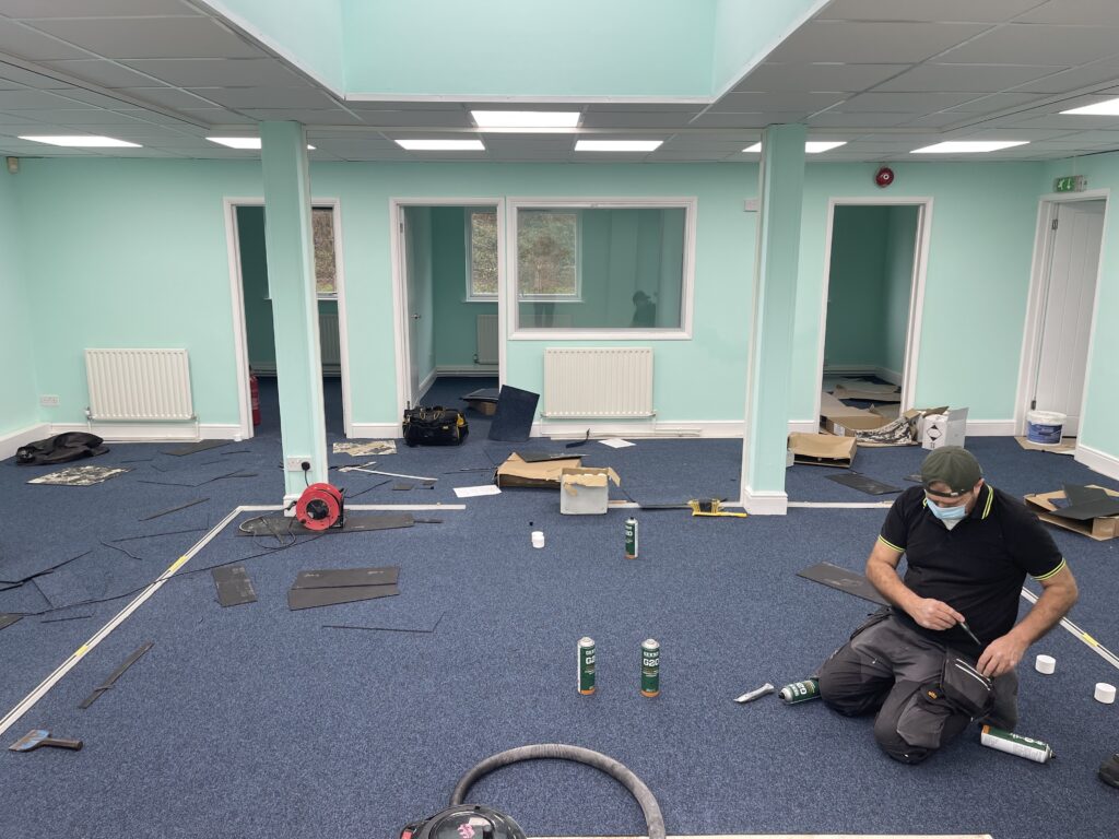 Close-up of commercial carpet tile fitting, office installation